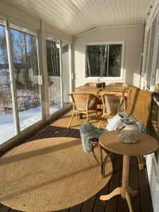a screened in porch with a table and chairs at Sjösikten in Ätran