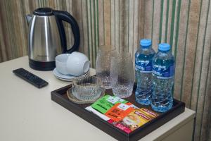 a tray with two bottles of water and glasses on a counter at Sport time Hotel & Spa in Tbilisi City
