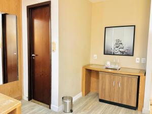 a room with a wooden door and a wooden table at AV Paulista - SP - Centro in São Paulo