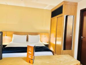 a hotel room with a bed with a sign on a table at AV Paulista - SP - Centro in São Paulo