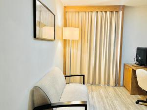 a living room with a couch and a tv and a window at AV Paulista - SP - Centro in São Paulo