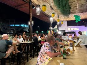 a group of people sitting at tables in a restaurant at Wild Rover Beach Mancora in Máncora +43 photos