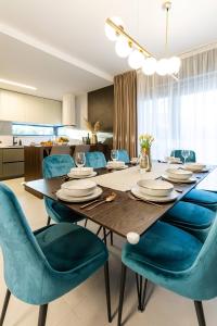 a dining room with a table and blue chairs at Luxury Villa Palermo in Vir