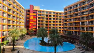a large swimming pool with palm trees in front of buildings at PB326 Beautiful studio in Phuket in Ban Mai Salae