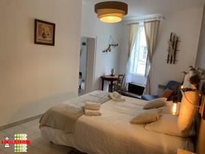 a bedroom with a large bed with towels on it at Echoppe Ancienne Boutique de cordonnier avec jardin privé in Aubeterre-sur-Dronne