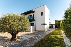 a white house with a tree in front of it at Luxury Villa Palermo in Vir