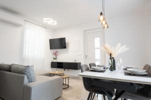 a white living room with a table and chairs at Apartman Turcic in Malinska