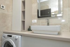 a bathroom with a sink and a washing machine at Apartman Turcic in Malinska +6 photos