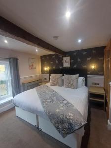 a bedroom with a large bed with white sheets at Fox and Pheasant Inn in Armathwaite