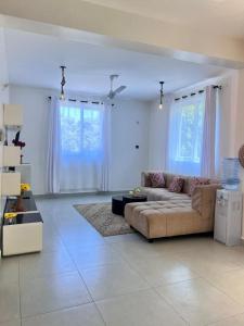 a living room with a couch and some windows at DIANI 2 Bed STUDIO in Gatunga