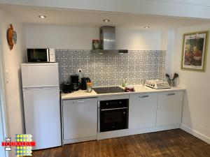 a kitchen with white appliances and a white refrigerator at Barque Fleurie Maison Retro avec Jardin et Parking au coeur d'Aubeterre-sur-Dronne in Aubeterre-sur-Dronne +18 photos