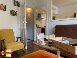 a living room with a pizza box on a table at Barque Fleurie Maison Retro avec Jardin et Parking au coeur d'Aubeterre-sur-Dronne in Aubeterre-sur-Dronne
