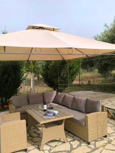 a patio with a couch and a table with an umbrella at Villa Argias Halikounas in Halikounas