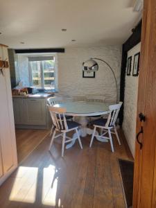 a kitchen with a table and chairs in a room at The Roost in Saltash