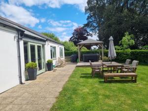 a patio with a picnic table and an umbrella at The Estate in Saltash +12 photos