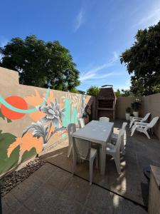 a patio with a table and chairs and a mural at Duplex Moderno en Chascomus in Chascomús