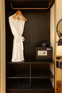 a cabinet with a dress and a radio in it at San Hotel & Pool in Hanoi