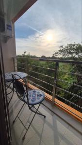 a balcony with a chair and a view of the forest at PB326 Beautiful studio in Phuket in Ban Mai Salae