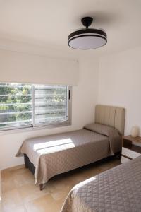 a bedroom with two beds and a window at Duplex Moderno en Chascomus in Chascomús