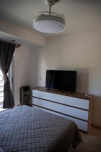 a bedroom with a bed and a flat screen tv at Duplex Moderno en Chascomus in Chascomús
