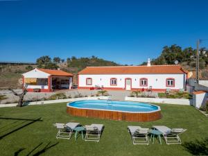 a house with a swimming pool with chairs and a building at Casa do Arlindo in São Bartolomeu de Messines
