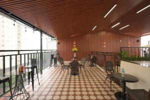 a room with tables and chairs on a balcony at San Hotel & Pool in Hanoi