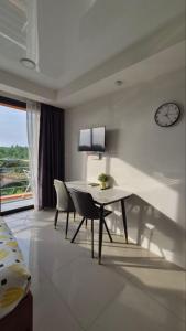 a dining room with a table and chairs and a clock at PB326 Beautiful studio in Phuket in Ban Mai Salae