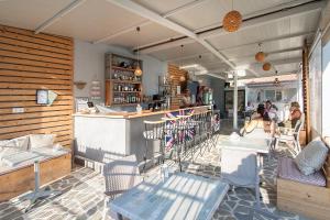 a restaurant with a bar and people sitting at tables at Dream House in Agia Paraskevi