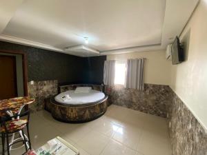 a bathroom with a bath tub in the corner of a room at Hotel Master Blue - Brasília in Ceilândia