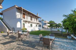 a patio with tables and chairs in front of a building at Dream House in Agia Paraskevi