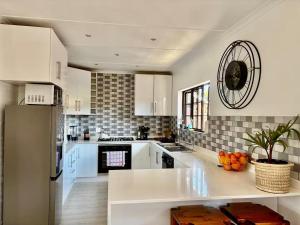 a kitchen with white cabinets and a white refrigerator at 4 Laddswood Lodge in Hilton +13 photos