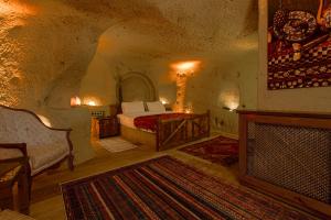 a bedroom with a bed and a fireplace at Babili Cappadocia Cave in Nevşehir