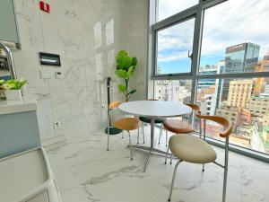 a table and chairs in a room with a window at The Comfort in Seoul
