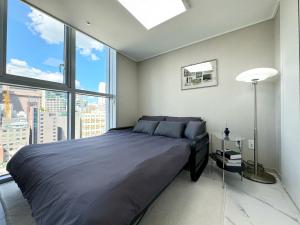 a bedroom with a large bed and a large window at The Comfort in Seoul