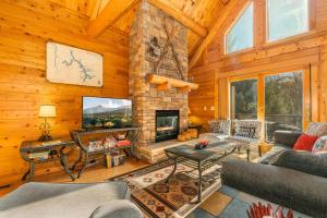 a living room with a stone fireplace in a cabin at A Wispful Dream in McHenry