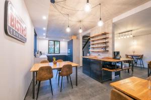 a kitchen and dining room with wooden tables and chairs at La Briqueterie in Saint-Aubin