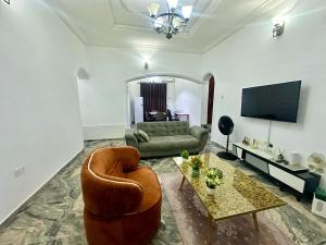 a living room with a couch and a chair at Resmay apartment in Abuja