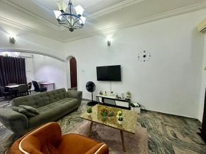 a living room with a couch and a table at Resmay apartment in Abuja +8 photos