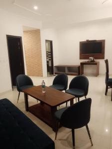 a living room with a table and chairs and a tv at Valley View in Dhanaulti