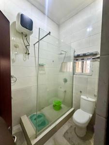 a bathroom with a glass shower with a toilet at Resmay apartment in Abuja