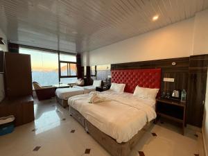 a bedroom with two beds and a red headboard at Valley View in Dhanaulti