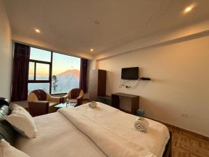 a hotel room with a bed and a large window at Valley View in Dhanaulti