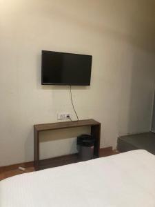 a flat screen tv on a wall in a bedroom at Hotel Grants Residency Colaba in Mumbai