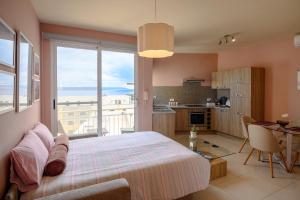 a bedroom with a bed and a kitchen with a view at Il-Kannizzata luxurious Gozo penthouse with sea view & pool in Għajnsielem