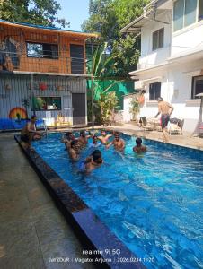 a group of people in a swimming pool at Simple Belle Stay ,Pool &Bar in Vagator +15 photos