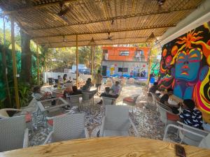 a group of people sitting in a room with a mural at Simple Belle Stay ,Pool &Bar in Vagator