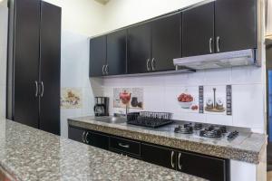 a kitchen with black cabinets and a counter top at Espacio Ideal 101 in Yopal +9 photos
