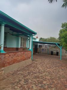 a building with blue columns and a brick yard at Carpe Diem in Brakpan