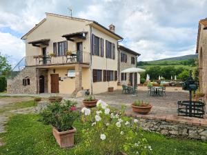 a house with a patio with tables and chairs at Podere Raggio Di Sole in San Gimignano