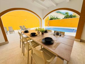 a dining room with a table and chairs and a pool at Casa Indigo Mazarron in Mazarrón